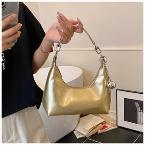 Détail du sac hobo croissant doré brillant avec décoration de breloque boule argent
