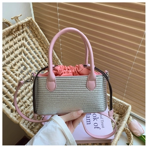 Detail of silver woven straw bag with pink leather handles and drawstring interior