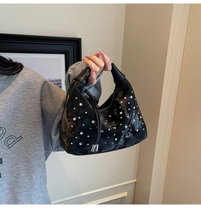 Detailed view of a black crescent hobo bag adorned with sparkling white rhinestones