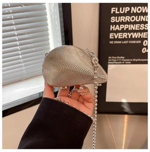 Detail der silbernen muschelförmigen Abendtasche mit Rillen und Perlenkettenriemen