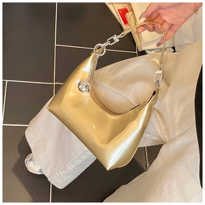 Détail du sac croissant doré métallisé avec chaîne argentée et pendentif sphérique