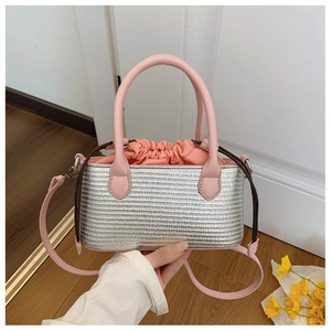 Detail of silver woven tote with pink drawstring closure and adjustable shoulder strap