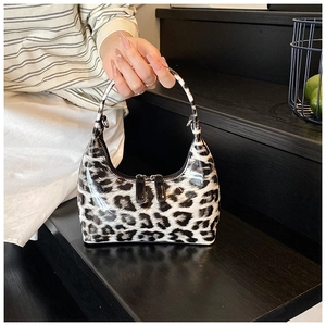 Close-up of hobo bag featuring leopard print patent leather and dual metal zippers