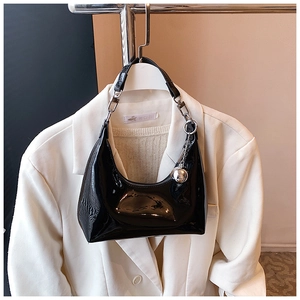 Détail du sac hobo en cuir verni noir brillant avec une chaîne en métal argenté