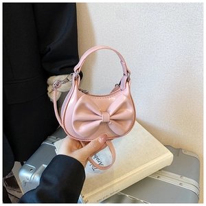Detailansicht einer rosa Mini-Tasche aus Lackleder mit großer Schleife und Silber-Reißverschluss