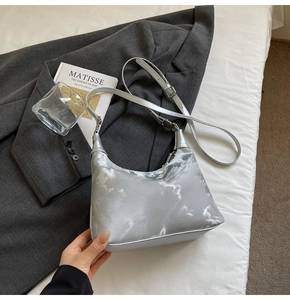 Detail shot of silver metallic crescent bag with marble texture and shiny leather finish