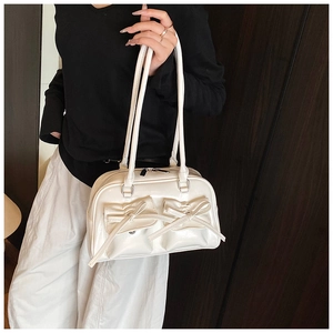 Detail of white glossy bowling bag with decorative bows and magnetic flap pockets