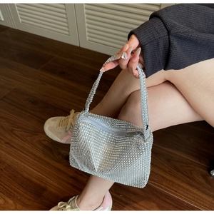 Detail of silver rhinestone handbag with sparkling crystal handle and metal zipper