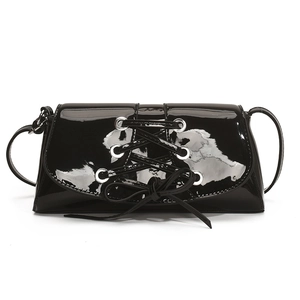 Chic black patent leather shoulder bag with stylish lace-up ribbon design and silver eyelets