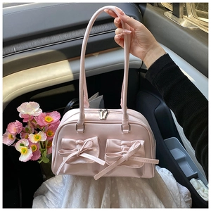 Detailed shot of a pink bowling handbag with cute ribbon pockets and silver zippers