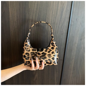 Close-up of glossy leopard print patent leather and smooth texture on the fashion handbag