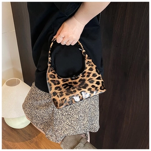 Close-up of glossy leopard print patent leather handbag with a metal zipper closure