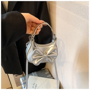 Detailansicht der Mini-Handtasche in Silbermetallic mit großer Schleife und Kette