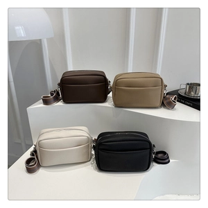 Detailed view of four litchi pattern PU crossbody bags with colorful striped fabric straps