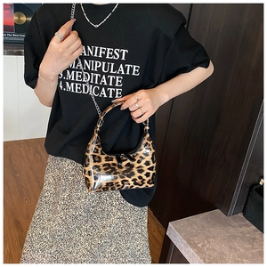 Detailed close-up of glossy leopard print hobo bag with sleek metal chain and black zipper