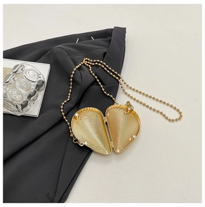 Detailansicht der goldenen herzförmigen Clutch mit radialer Textur und Gliederkette