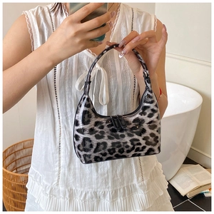 Detail of leopard print hobo bag in shiny patent leather with dual metal zippers