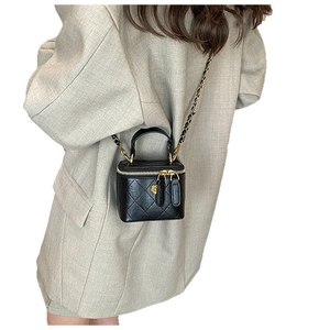 Mini quilted leather crossbody bag with gold flower logo and chain strap shown on model