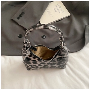 Macro shot of hobo bag interior with gold lining, zipper pocket, and leopard patent leather