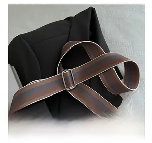 Detail of adjustable striped fabric shoulder strap with silver metal buckle on bag