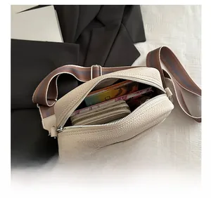 Top view of beige lychee texture crossbody bag showing spacious interior and strap