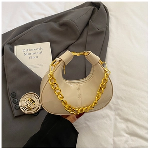 Detail of hobo handbag with glossy finish, gold chain, and detachable leather strap