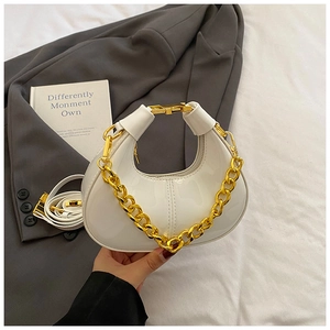 Detail of white glossy mini dumpling bag with thick gold chain handle and detachable strap