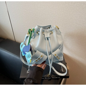 Close-up of light blue lychee pattern leather bucket bag with drawstrings and golden hardware