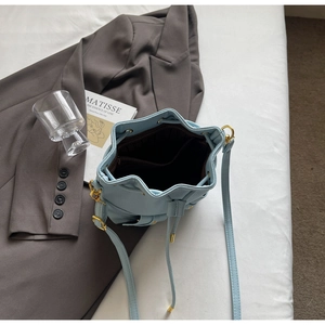 Macro view of drawstring bucket bag interior with dark lining and zipper pocket