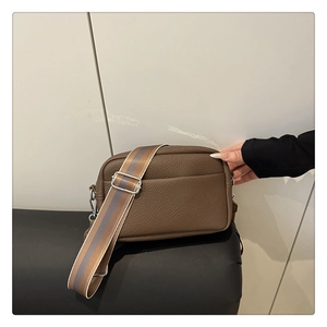 Detail of brown litchi pattern PU leather crossbody bag with wide knit shoulder strap