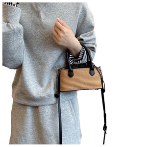 Minimalist straw handbag with black leather straps and drawstring liner for women