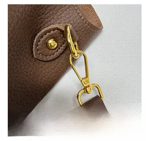 Detail of a brown lychee pattern leather bag with a detachable gold metal hook buckle