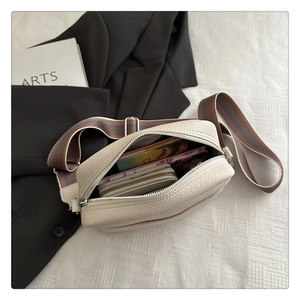 Detail of the cream litchi texture PU bag interior showing space for wallets and cards