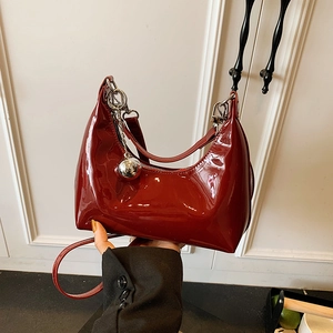 Sac croissant en cuir verni bordeaux avec breloque boule argentée et fini brillant