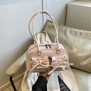 Pink minimalist bowling shoulder bag with 3D bow accents in a soft aesthetic scene