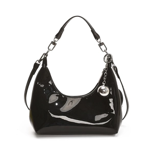 Sac hobo croissant en cuir verni noir avec charm boule argentée sur fond blanc pur