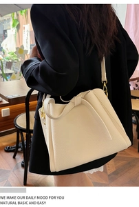 Detail of cream lychee leather handbag with knot decoration and gold hardware hooks
