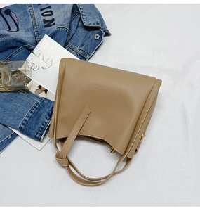 Top view of khaki pebbled leather bucket bag with gold hardware and stylish accessories