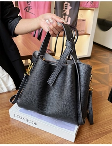 Detail of black lychee grain leather tote bag with gold hardware and removable strap