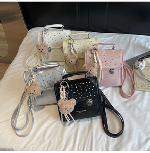 Detail view of stylish crossbody bags with sparkling rhinestones and cute bear charms
