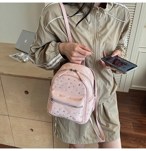 Close-up of light pink quilted mini backpack with sparkling rhinestone decorations