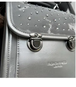 Close-up of sparkling rhinestone embellishments and vintage metal buckles on a silver backpack