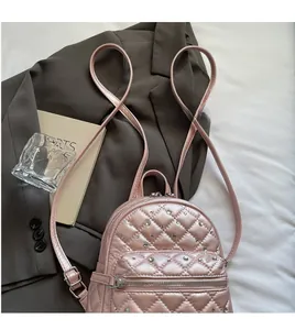 Pink quilted mini backpack featuring sparkling rhinestone accents and slim straps