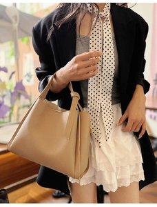 Detail of premium beige tote bag showing high-quality leather texture and knotted handle