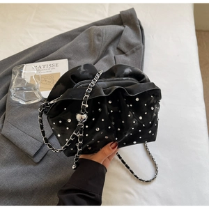 Detail of black pleated cloud bag with silver rhinestones and chain strap with ball charm