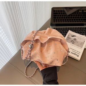 Close-up of pink ruched cloud bag with silver chain strap and sparkling rhinestones
