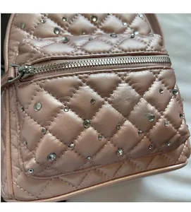 Close-up of quilted rose pink backpack featuring rhinestones and silver zipper detail
