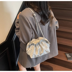 Silver pleated cloud bag with rhinestones and chain strap shown on a model