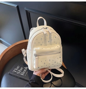 Close-up of cream-white leather mini backpack featuring teardrop rhinestone embellishments