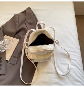 Detail of mini cream white quilted leather backpack with sparkling rhinestone embellishments